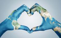 What’s Missing in Positive Psychology? Female hands, painted in the world map, forming heart shape isolated on blue background
