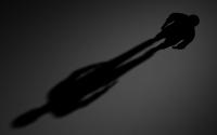Black Outline of a Man and his Shadow on a Dark Background
