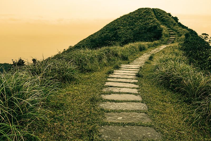 Fairy tale landscape and stepping stone path over a hill on the horizon at the Caoling Historic Trail in Taiwan